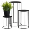 Three black metal plant stands of varying heights, with a potted artificial plant on the smallest stand. Náhľad obrázku produktu