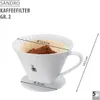 A white ceramic coffee filter cone with coffee grounds and a paper filter, showing dimensions with overlaid text. Produktbild-Vorschau
