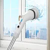 A white electric cleaning brush with a telescopic pole is being used to clean a window, with water splashing. Voir les images du produit