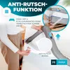 A person is demonstrating the anti-slip function of a mattress topper by attaching elastic straps to the corners of a mattress. Produktbild-Vorschau