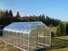 A greenhouse is shown in a grassy outdoor setting with trees in the background. Anteprima dell’immagine prodotto
