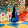 A blue and green hanging chair in a colorful indoor playground. Produktbild-Vorschau