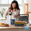 A woman is pouring coffee into a cup in a kitchen, with a sandwich maker and breakfast items on the counter. Produktbild-Vorschau