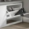 A white shoe cabinet with a gray upholstered seat on top, showing two pairs of shoes inside. Anteprima dell’immagine prodotto
