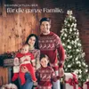 A family in matching Christmas sweaters posing in front of a decorated Christmas tree and a fireplace. Produktbild-Vorschau