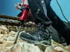 A person is using a jackhammer to break rocks, wearing work boots. Anteprima dell’immagine prodotto
