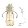 A baby bottle with a crown-shaped lid and a straw attachment, presented against a white background. Produktbild-Vorschau