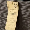 A close-up of a product tag with eco-friendly information. Produktbild-Vorschau