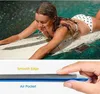 A young woman is surfing on a surfboard in the water, with a waterproof phone case visible on the surfboard. Below, a close-up shows the edge and air pocket of a phone case. Podgląd zdjęcia produktu