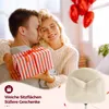 A couple exchanging a gift, with a fluffy chair and balloons in the background. Náhled obrázku produktu