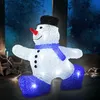 A lighted acrylic snowman decoration with a black hat, red nose, blue scarf, and blue boots, set against a dark, frosted window background with some fairy lights and star decorations in the foreground. Produktbild-Vorschau