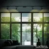 A modern living room with large windows overlooking a lush green forest. The room features a comfortable sectional sofa and a subtle Buddha statue. Anteprima dell’immagine prodotto