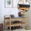A shoe rack with a bench seat in a hallway or entryway, decorated with plants and artwork on the wall. Produktbild-Vorschau