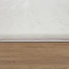 Close-up view of the edge of a fluffy white rug on a wooden floor. Anteprima dell’immagine prodotto