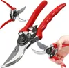 A set of red-handled pruning shears is displayed against a white background, with one pair being held by a hand. Podgląd zdjęcia produktu