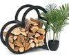 A black metal heart-shaped firewood rack filled with logs, placed next to a potted plant. Podgląd zdjęcia produktu