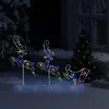 Christmas decorations of illuminated reindeer and a sleigh in a snowy outdoor setting at night. Produktbild-Vorschau