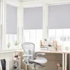 A home office setting with a desk, chair, and window blinds. Produktbild-Vorschau