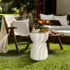 An outdoor patio scene with a chair, sofa, and side table set up for relaxation. Anteprima dell’immagine prodotto