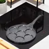 A multi-section frying pan for making small pancakes or eggs sits on a modern induction stovetop. Produktbild-Vorschau