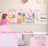 A young child plays with a large, pink and white activity wall mounted on a light gray wall. The activity wall features various educational toys and games. Produktbild-Vorschau
