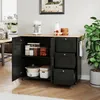 A black kitchen cart with a wooden countertop is shown in a kitchen setting. The cart has open doors revealing shelves with storage containers and pots, and three drawers are visible on the right side. A plant is to the right of the cart. Voir les images du produit