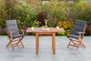 A wooden garden furniture set with two chairs and a table on a paved patio, surrounded by plants and flowers. Náhled obrázku produktu