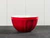 A red ceramic bowl with a white interior sits on a dark gray surface against a white paneled background. Produktbild-Vorschau