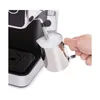 A hand is holding a milk frothing pitcher under the steam wand of an espresso machine. Produktbild-Vorschau