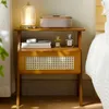 A bedside table with a lamp, alarm clock, books, and perfume bottles. Náhled obrázku produktu