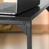 Close-up of a black wooden table with a metal frame, showing a corner detail and a laptop on top. Produktbild-Vorschau