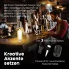 A man is working on a laptop at a bar counter, with a bottle lamp and beer glasses on the counter. Anteprima dell’immagine prodotto