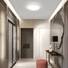 A modern hallway with a ceiling light, a console table with a lamp, and a mirror. Produktbild-Vorschau