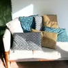 A collection of decorative pillows arranged on a sofa, with sunlight casting shadows. Náhľad obrázku produktu
