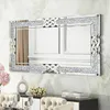A rectangular mirror with a crystal-encrusted frame and a decorative knot design is displayed on a wall above a console table. Produktbild-Vorschau