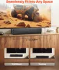 A soundbar is shown placed on a wooden cabinet in front of a large TV displaying a desert scene with a vehicle. Dimensions are indicated with lines and text. Two smaller images below show wall-mount and desktop placement options. Náhľad obrázku produktu