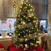 A decorated Christmas tree with lights and ornaments, set up indoors near a window. Produktbild-Vorschau