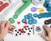 A poker set with chips, cards, and dice laid out on a white surface. Podgląd zdjęcia produktu