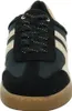 A close-up, front view of a black sneaker with gold accents and a tan sole. Voir les images du produit