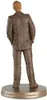A figurine of a character in a pinstripe suit, viewed from the back, standing on a circular base. Produktbild-Vorschau