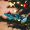 A decorative peacock ornament with a feathered tail is clipped onto a Christmas tree branch, with blurred Christmas lights and ornaments in the background. Produktbild-Vorschau