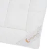 A close-up view of a white comforter with a label attached to the corner. Produktbild-Vorschau