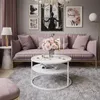 A stylish living room with a pink sofa, coffee table, and artwork. Produktbild-Vorschau