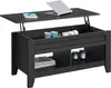 A black lift-top coffee table with a laptop and notebook on the raised surface, and mugs and headphones inside the storage compartment. The lower shelf holds books and decorative candles. Produktbild-Vorschau