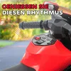 Close-up of a red toy motorcycle's handlebars and control panel, with musical notes overlaid. Produktbild-Vorschau