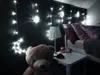 A bedroom scene with fairy lights, a teddy bear, and a bedside table. Náhľad obrázku produktu