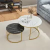 A set of two nesting coffee tables with marble-look tops and gold metal frames, placed on a rug next to a sofa and a TV stand. Náhled obrázku produktu