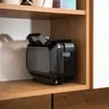A black waffle maker is stored on a wooden shelf. Voir les images du produit