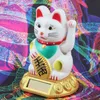 A solar-powered lucky cat figurine sits on a decorative base against a vibrant, abstract patterned background. Produktbild-Vorschau
