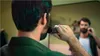 A man is trimming his beard in front of a mirror. Náhled obrázku produktu